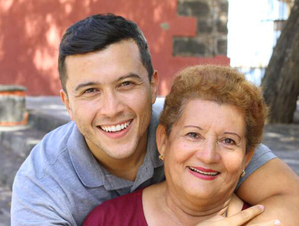Smiling young man and older woman posing together outdoors at dental practice in Sharpsville, PA.