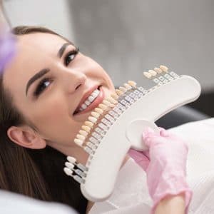 Woman receiving dental treatment with intraoral scanner device at dental clinic